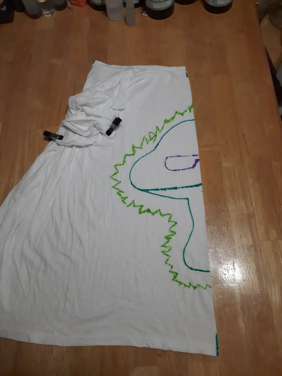 A shirt laid out with a planned design before it is tied